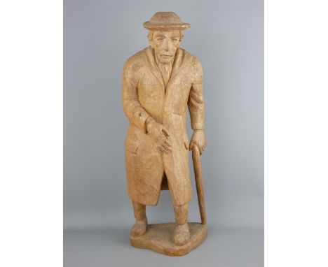 A POSSIBLY CONTINENTAL CARVED WOOD FIGURINE of an elderly gentleman in a hat and overcoat with walking stick, 63 cms high, in