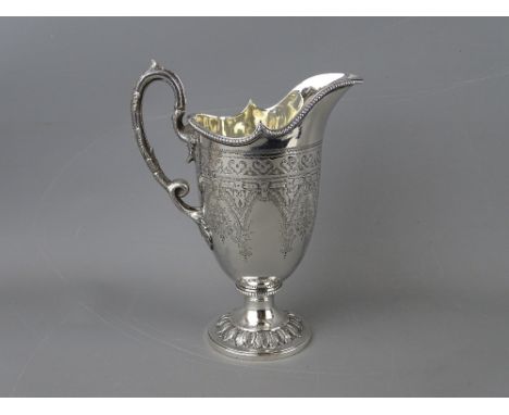 A SILVER HELMET SHAPED JUG with leaf cast handle, pedestal circular base and chased decoration, London 1871, 7.6 troy ozs, 15