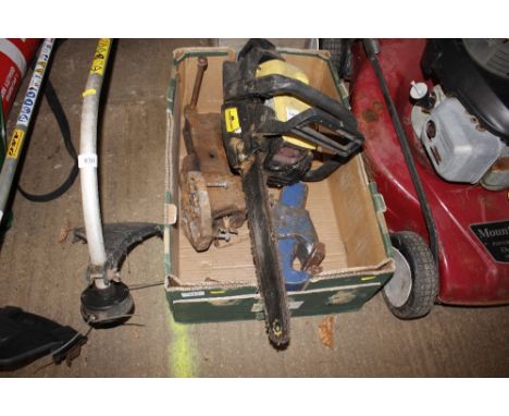 A box containing a McCulloch chainsaw and two bench vices