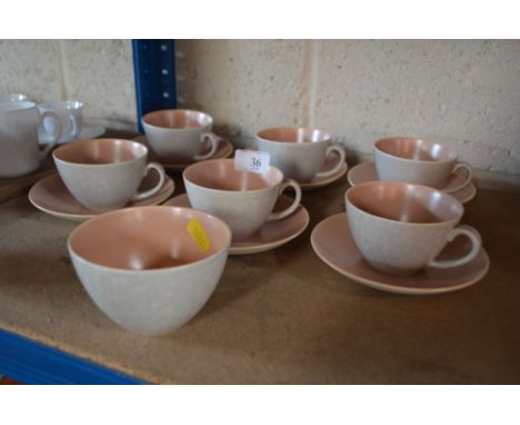 A collection of Poole twin tone teacups and saucers; and a matching sugar bowl