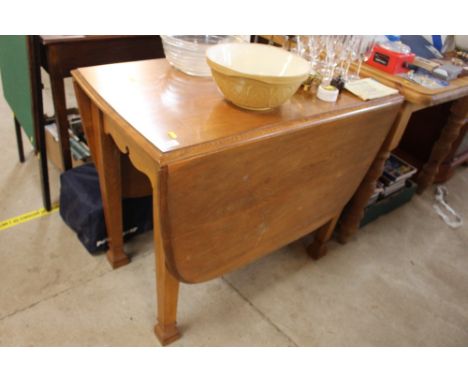 A light oak drop leaf dining table 