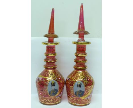 A pair of Turkish ruby glass decanters, 31cm and 32cm