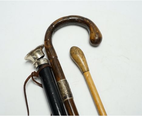 Three various walking canes including an inlaid tortoiseshell 'hidden compartment' cane, (two silver mounted), 90cm in length