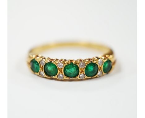 A modern 18ct gold and five stone emerald set half hoop ring, with diamond chip spacers, size K/L, gross weight 3 grams.