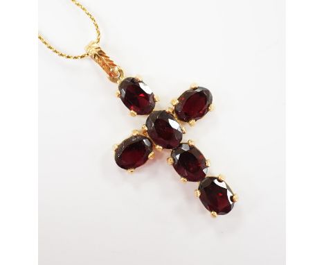 A modern 750 yellow metal and six stone oval cut garnet set cross pendant, 38mm, gross weight 3.5 grams, on a gilt metal chai