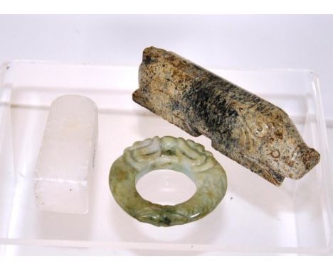 Three various Chinese carved stone amulets including carved pig figure, (length 10cm approx); a carved greenstone amulet; and