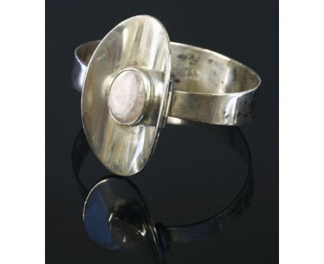 A sterling silver Danish modernist bangle, c.1970,by Willi Paul Scheelke for Tønder, an oval cabochon rose quartz, rub set to