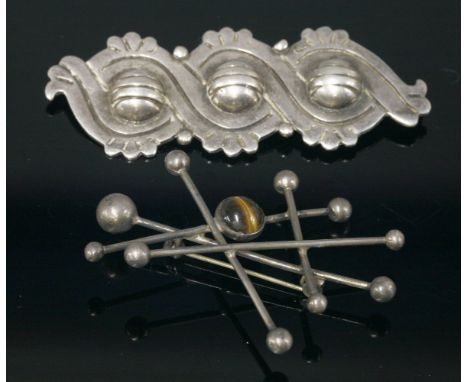 An early sterling silver Mexican brooch, c.1940,by Hector Aguilar, with a series of three incised domes to overlapping bands,