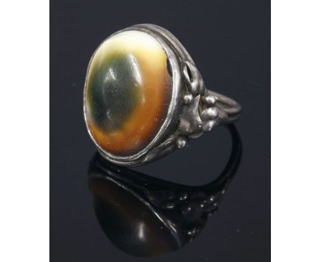 An Arts and Crafts silver operculum ring,with applied leaf and bead shoulders to a double wire shank.Finger size L