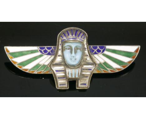 A German, Egyptian Revival, silver gilt brooch,with a death mask to the centre, champlevé enamel striped decoration in blue a