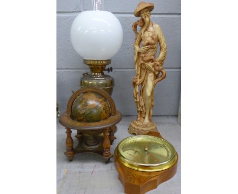 A barometer, an oil lamp, a figure and a globe **PLEASE NOTE THIS LOT IS NOT ELIGIBLE FOR POSTING AND PACKING** 