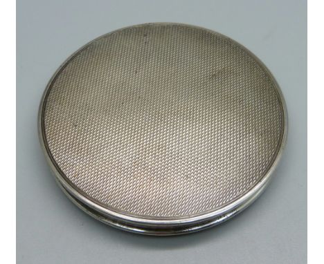An engine turned silver compact, lacking mirror 