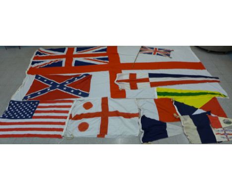 A collection of flags; a large Navy white ensign flag, 4.6m x 2.1m, a Union Jack with broad arrow on the header, signal flags