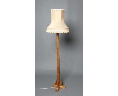 A PETER HEAP ADZED OAK STANDARD LAMP, the faceted tapering stem on stepped cruciform base, carved rabbit trademark in high re