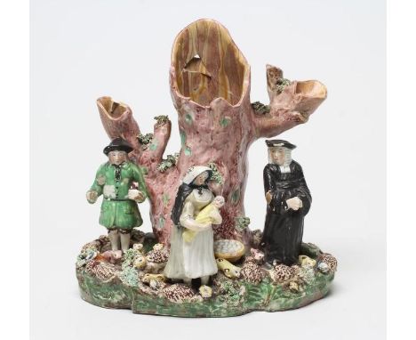 A PEARLWARE "TITH PIG" SPILL VASE, late 18th century, typically modelled as the farmer with his wife and baby standing beside