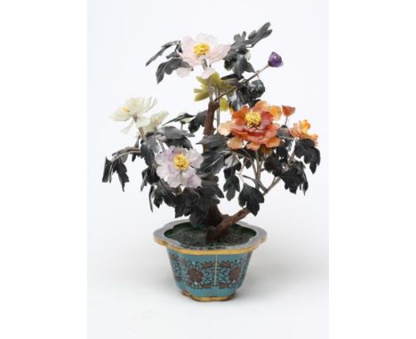 A CHINESE CLOISONNE ENAMEL AND HARDSTONE TREE, the blue ground rounded hexagonal pot with dark red stylised flowerheads inset