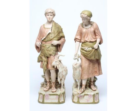 A LARGE PAIR OF ROYAL DUX BISQUE PORCELAIN FIGURES, early 20th century, modelled as a young goatherd and shepherdess, both we