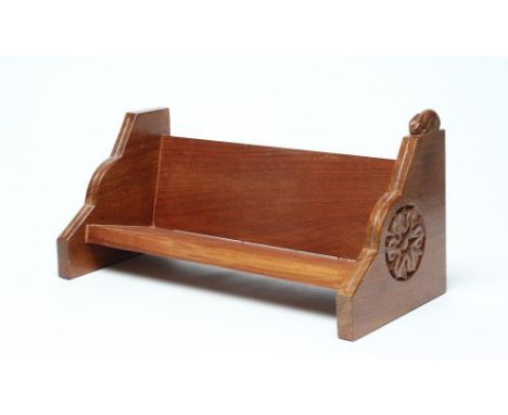 A PETER HEAP OAK BOOK TROUGH, the moulded tapering end supports each carved with a Yorkshire rose and one surmounted by a car