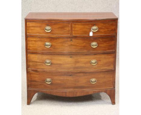 A REGENCY MAHOGANY BOWED CHEST, the moulded edged top over two short and three long drawers with brass ring handles, shaped a