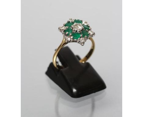 A DIAMOND AND EMERALD CLUSTER RING, the central diamond of approximately 0.20cts claw set to a border of six round diamond po