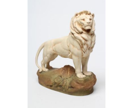 A ROYAL DUX BISQUE PORCELAIN LION, early 20th century, modelled standing on a rocky outcrop, pink patch and blue printed mark