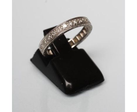 A DIAMOND ETERNITY RING with point set small stones to an engraved white shank, marked 18ct, size K  (Est. plus 21% premium i