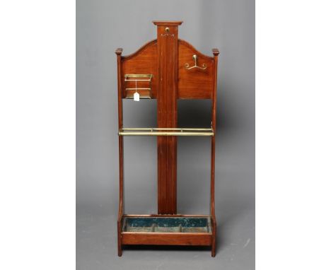 AN EDWARDIAN MAHOGANY STICK STAND, the arched open back with central splat carved with linen fold, brass stick rail and fitti