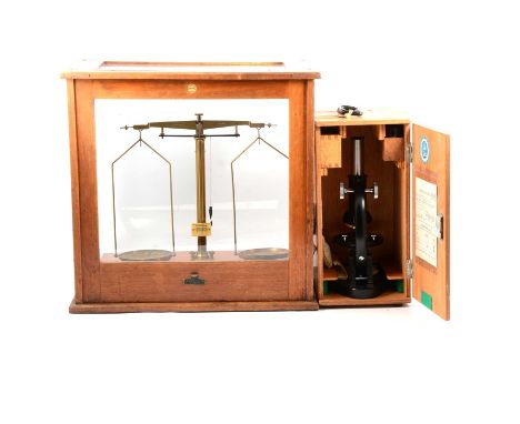 A student microscope, set of lab balance scales in case with three part sets of weights.