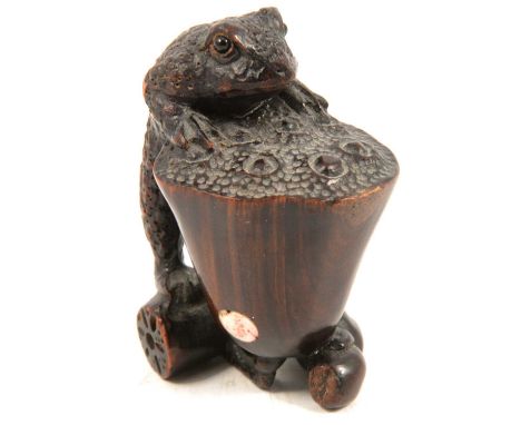 Signed wooden netsuke of a frog, 50mm.Condition report:The holes are part of the decoration.