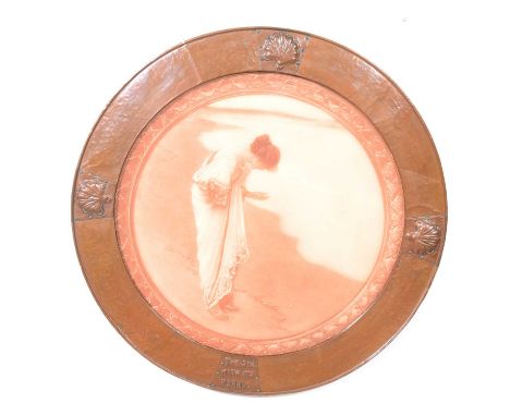 An Arts and Crafts circular copper frame, embossed with shell motifs and 'The sea hath its pearls', enclosing a sepia print o