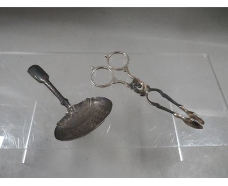Antique silver scissor sugar nips and a George III silver caddy spoon (2)