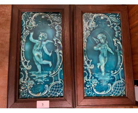 A pair of Oak framed antique Minton &amp; Hollins &amp; Co ceramic panels depicting cherubic figures / putti. (2)