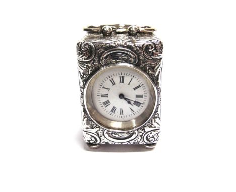 AN VICTORIAN SILVER MINIATURE CARRIAGE CLOCK  circular white enamel dial with blued steel hands, the rococo style embossed ca