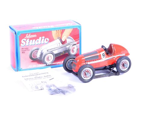 A Schuco Studio made tinplate clockwork model No.1050 ' Mercedes Grand Prix 1936 '. The model finished in red and complete wi