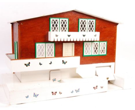 A charming vintage 1960's Swiss Chalet doll's / dolls house having a twin hinged lid with opening window panels, garage door 