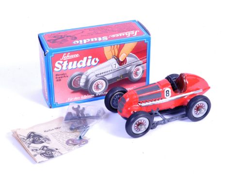 A Schuco Studio made tinplate clockwork model No.1050 ' Mercedes Grand Prix 1936 '. The model finished in red and complete wi