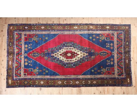 A FINE BIDJAR HAND MADE CARPET having a blue stepped medallion centred with a red on ivory stepped medallion on a large red p