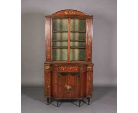 AN EARLY 20TH CENTURY PAINTED SATINWOOD BOOKCASE-CABINET, having an arched pediment painted with a ribbon tied portrait cameo