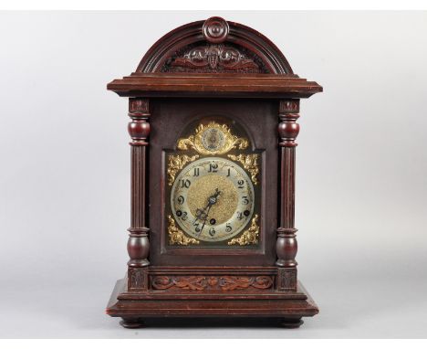 AN EDWARD VII MAHOGANY STAINED MANTEL CLOCK with arched case, the cornice with central roundel above a leaf scroll panel, the