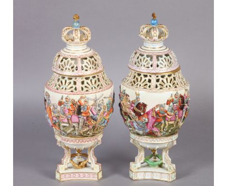 A PAIR OF LATE 19TH CENTURY NAPLES DOCCIA VASES AND COVERS of urn form, relief moulded with battle scenes beneath pierced nec