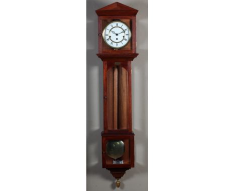 A TEAK CASED WALL CLOCK, the panelled architectural pediment above a glazed hood, white enamel dial with Roman numerals, the 