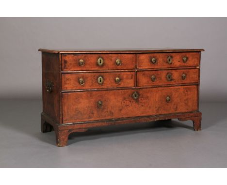 A FIGURED WALNUT AND HERRINGBONE BANDED THREE HEIGHTS CHEST of four short and  one deep drawer, brass oval escutcheons, back 