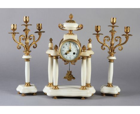 A LATE 19TH CENTURY FRENCH WHITE MARBLE AND GILT METAL three piece clock garniture, the clock with drum shaped case with urn 