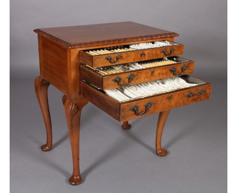 A WALNUT TABLE CANTEEN OF EPNS CUTLERY having a gadroon rim, on cabriole legs with pad feet, the three graduated drawers fitt