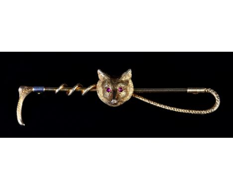 A GEORGE V FOX MASK AND CROP STICK PIN in 14ct gold, set to the eyes with ruby cabochons, with 9ct rose gold pin, approximate