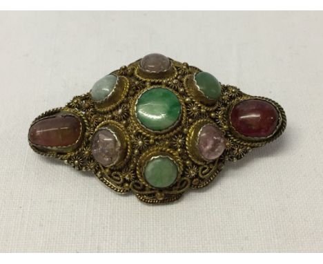 Ornate brooch set with semi-precious stones to include jade, amethyst, adventurine, larrimar, rose and cherry quartz. Filligr