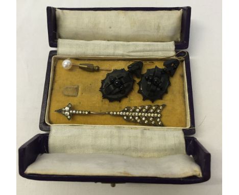 A box containing a pair of jet earrings, a pearl stick pin and a white metal past arrow.