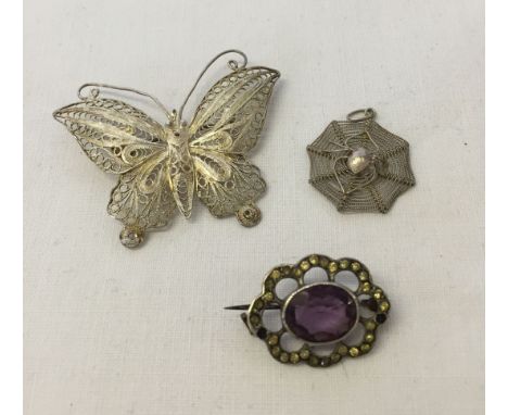 A filigree silver butterfly brooch together with a pendant featuring a spider on a web and a silver marcasite brooch with cen