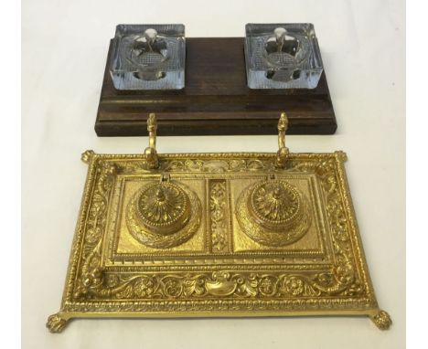A brass writing stand inkwell holder together with a wooden inkwell holder with glass inserts.