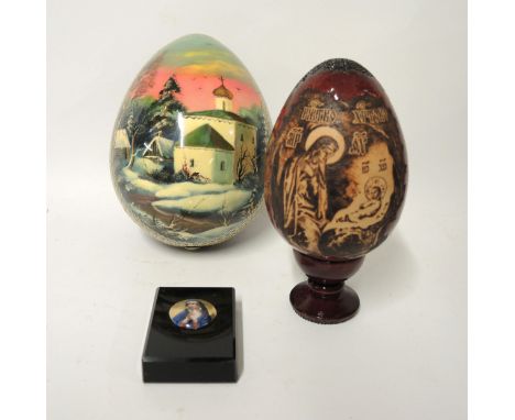 Two modern Russian wooden Easter eggs, one with stand, an enamel decorated brass coptic cross and a small paperweight decorat